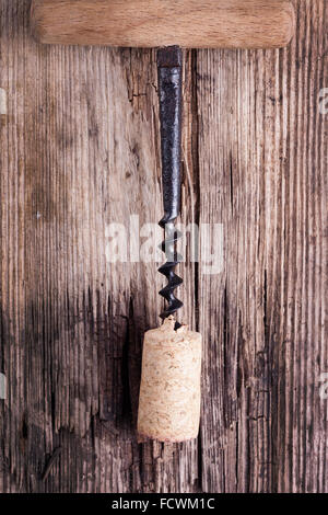 Vecchio cavatappi e tappo per bottiglia di vino su una superficie di legno macro closeup Foto Stock