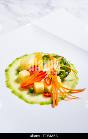 Creazione di insalata Fitness fresca insalata sulla piastra. Cetriolo, baby spinaci, carota, cicoria, ananas fresco, peperoni, arancione fille Foto Stock