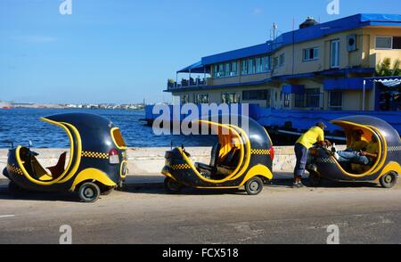 Tre Cocotaxis e i loro piloti in Havana Harbour in 26 dicembre 2013. Foto Stock