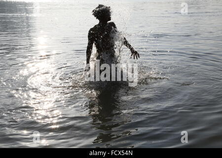 L'uomo gli schizzi in il Gange acqua in Kolkata, India - visione di libertà Foto Stock