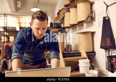 Hipster titolare di azienda lavora sul computer portatile nel suo lavoro moderni Foto Stock