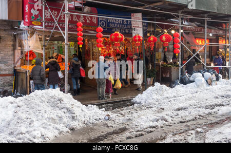 Gli acquirenti asiatici sulla Mott Street a Chinatown in New York City dopo 2016 tempesta invernale Jonas Foto Stock