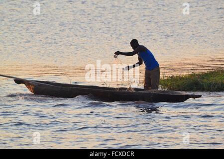 Pescatore al tramonto sul fiume Chobe tra Botswana e Namibia, Africa Foto Stock