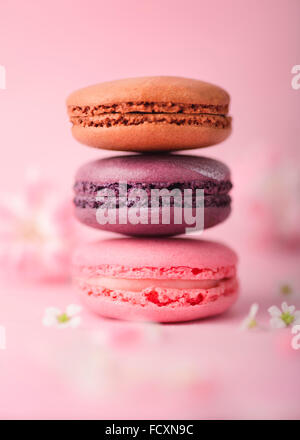 Pila di tre differenti macarons sulla backround rosa Foto Stock