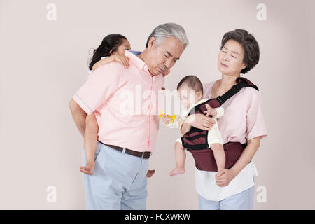 Vecchia coppia stanco di prendersi cura dei loro nipoti Foto Stock
