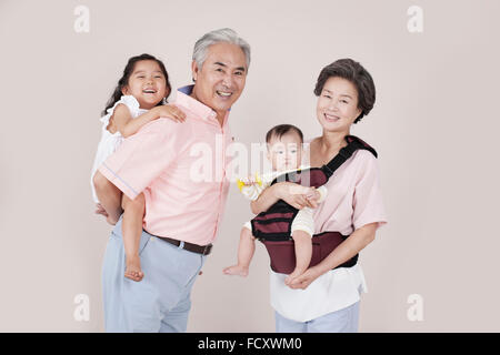 Sorridente vecchio paio di prendersi cura di loro nipoti Foto Stock