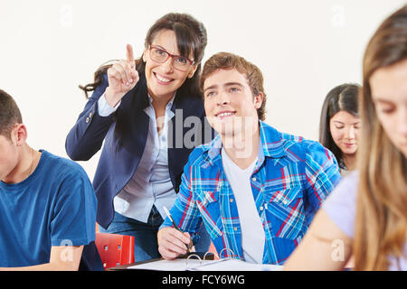 Insegnante aiuta a uno studente durante un test e solleva il suo dito Foto Stock