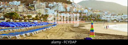 TENERIFE, Spagna - 17 gennaio 2013: spiaggia sabbiosa con blue di ombrelloni e lettini, di Los Cristianos, Tenerife, Isole Canarie, Spagna Foto Stock