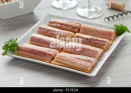 Piatto con filetti di anguilla affumicata su pane tostato come un partito snack Foto Stock