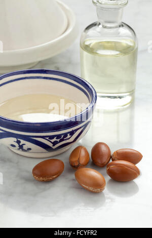 Cup con marocchino olio di argan e i dadi per i prodotti cosmetici Foto Stock