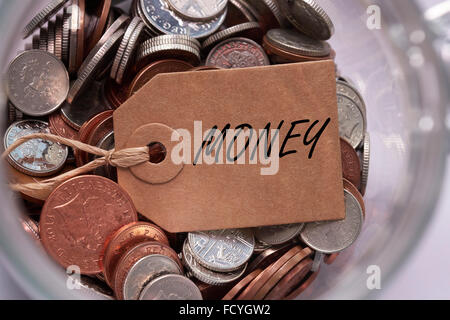 Etichetta di denaro su British miscelati delle monete in euro all'interno di un vaso di vetro concept Foto Stock