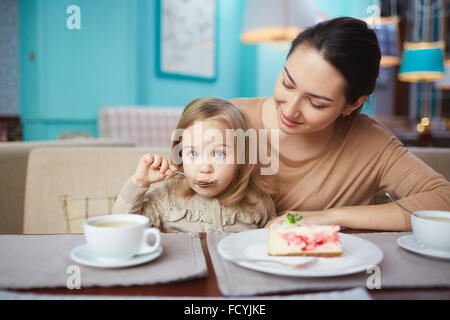 Giovane donna e la sua piccola figlia mangiare in cafe Foto Stock