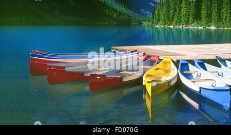 Canoe colorate a un dock su un bellissimo lago di montagna. Foto Stock