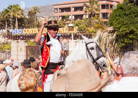 Cavaliere in costume tradizionale cavalcando attraverso la folla alla fine del San Sebastian fiesta Costa Adeje Tenerife Foto Stock