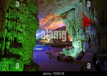 I visitatori in una grande caverna con formazioni stalattitiche e stalagmitiche più, Dau Go grotta, in calcare carso in Halong Bay, Vietnam Foto Stock