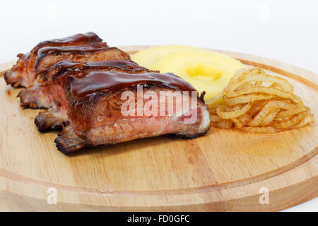Costolette di maiale con cipolle fritte e mele barbecue Foto Stock
