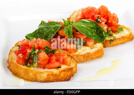 Freschi Fatti in casa e croccanti Antipasto Italiano chiamato Bruschetta condito con pomodoro, aglio e basilico Foto Stock