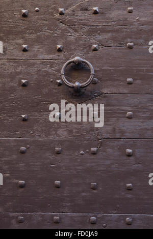 Vecchio paracolpi di metallo sul marrone di legno verniciato cancello fissata con rivetti a Bergamo, Lombardia, Italia. Foto Stock