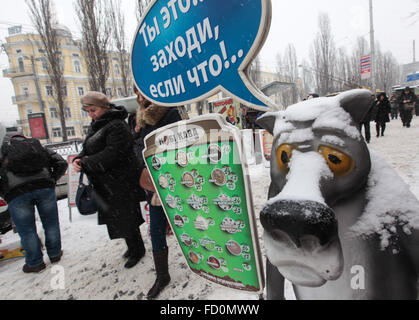 Kiev, Ucraina. 25 gennaio, 2016. Gli ucraini a piedi passato una strada pubblicità durante una nevicata nel centro di Kiev. Una nevicata ha colpito la città all'inizio della giornata. Ukrainian idro Centro Meteorologico annunciato avviso di tempesta nella capitale Kiev e in alcune regioni in Ucraina per i prossimi giorni. © Serhii Nuzhnenko/Pacific Press/Alamy Live News Foto Stock