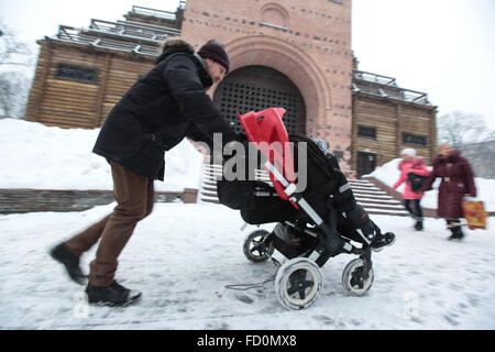 Kiev, Ucraina. 25 gennaio, 2016. Un uomo spinge una carrozzina come lei cammina in durante la nevicata a Kiev. Nevicata che ha colpito la città in precedenza il 25 gennaio. L'Ucraino idro Centro Meteorologico ha annunciato un avviso di tempesta a Kiev e in alcune altre regioni in Ucraina nei prossimi giorni. © Serhii Nuzhnenko/Pacific Press/Alamy Live News Foto Stock