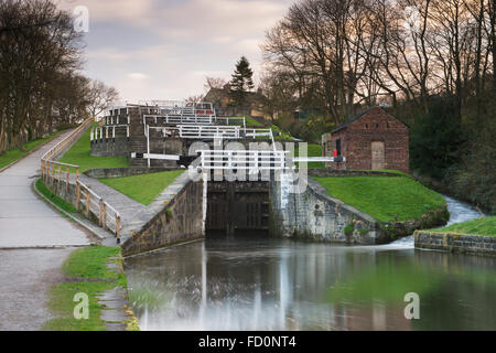 Primavera sunrise presso l'aumento di cinque serrature su Leeds e Liverpool Canal, Bingley, West Yorkshire, Inghilterra, GB, Regno Unito - esposizione a lungo utilizzato. Foto Stock