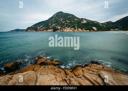 Costa rocciosa e vista D'Aguilar, picco a Shek O Beach, sull'Isola di Hong Kong, Hong Kong. Foto Stock