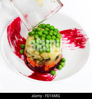 Preparazione di insalata di bietole, patate, piselli verdi e sottaceti, insalata russa Foto Stock