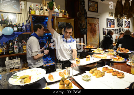 Un barman basco versando tradizionale vino bianco chiamato Txakoli nel modo tradizionale. Foto Stock