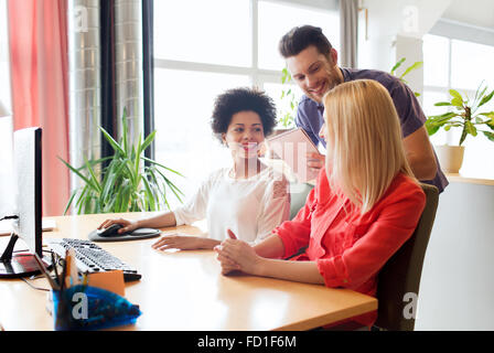 Happy team creativo con il computer in ufficio Foto Stock