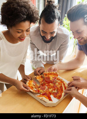 Happy business team di mangiare la pizza in ufficio Foto Stock