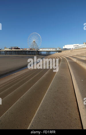Passi verso il basso alla spiaggia sul lungomare di Blackpool con molo centrale in background Foto Stock