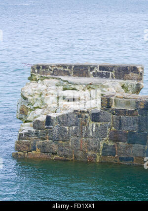 Lamorna Cove danneggiato la parete del porto, Cornwall, Regno Unito Foto Stock