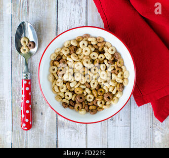 Ciotola di cereale con cucchiaio e tovagliolo sulla tavola di legno Foto Stock