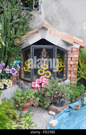 Piccola statua di un cattolico Patrono san Gennaro in un santuario sul ciglio della strada nel giardino di una casa privata in Cilento in Italia meridionale Foto Stock