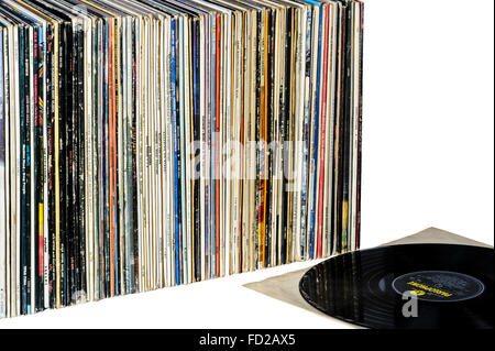 Una fila di long playing album in vinile con un disco recante su di esso il manicotto interno. Foto Stock