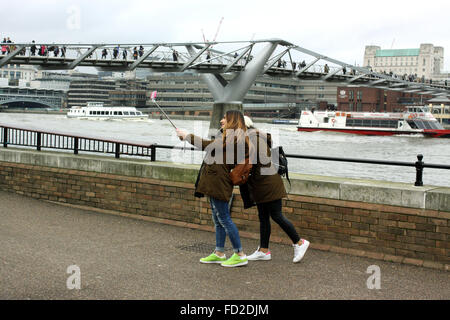 I turisti prendendo un selfie con un bastone selfie sulla Southbank, Londra Foto Stock