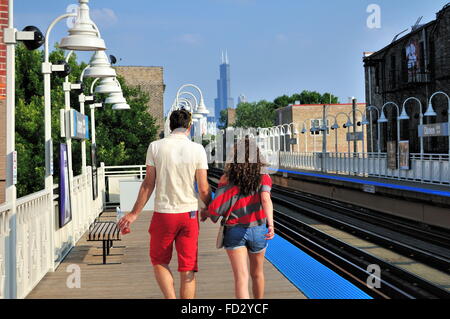 Una mano nella mano matura a piedi lungo la piattaforma al CTA Linea Blu Damen Avenue stazione in Chicago, Illinois, Stati Uniti d'America. Foto Stock