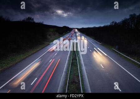 Sentieri di luce del veloce movimento di automobili sulla trafficata autostrada britannica Foto Stock