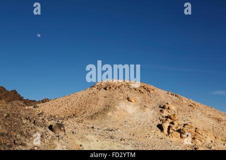 La luna sorge al di sopra di zolfo-cucita sulla roccia del monte Teide nel Parco Nazionale del Teide Tenerife, Spagna. Foto Stock