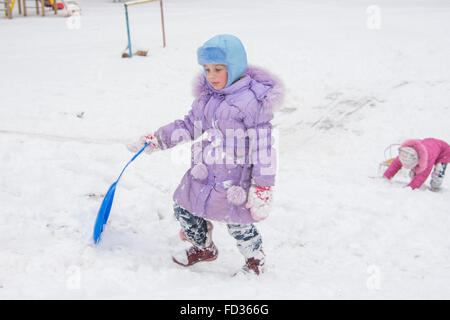 Cinque anni di ragazza a cavallo su un gelido nevoso hill Foto Stock