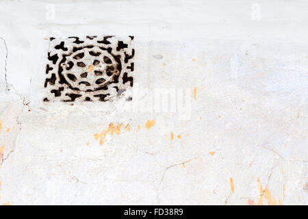 Vintage la griglia di ventilazione nel vecchio muro intonacato con crepe e graffi. Grungy superficie di calcestruzzo. Grande sfondo o tex Foto Stock