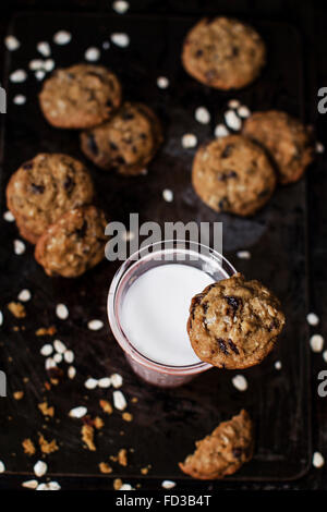 Ricca oat cookies con uvetta e scaglie di cioccolato, avente bordi croccanti e saporite fragrante centro. Impostare su un vintage backgro Foto Stock