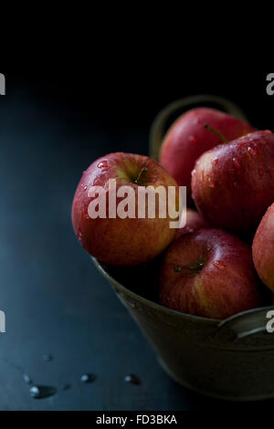 Carni rosse mele in una ciotola su sfondo scuro Foto Stock