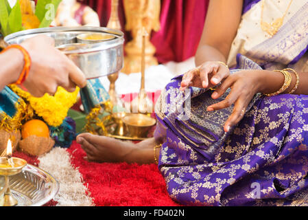 Donna preghiere ricevute dal sacerdote. La tradizione indiana indù ear piercing cerimonia. India rituali particolari eventi. Foto Stock