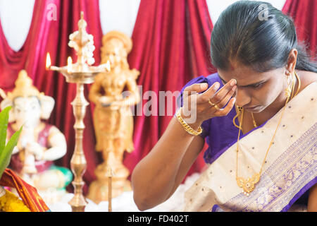 Donna indù mettendo bindi o la marcatura sulla sua fronte durante la Indian riti religiosi tradizionali, la tradizione dell'Induismo. Foto Stock