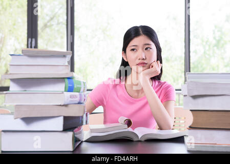 Studente universitario che studia in biblioteca Foto Stock