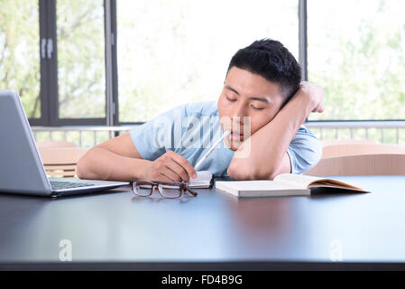 Studente di College di addormentarsi in libreria Foto Stock