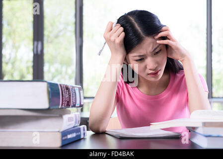 Studente universitario che studia in biblioteca Foto Stock