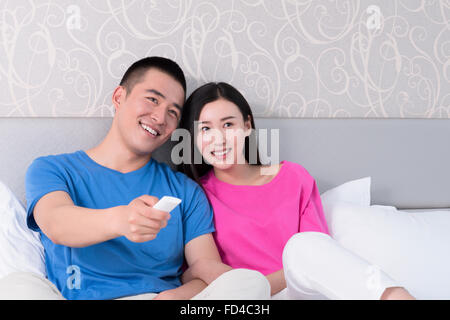 Coppia giovane guardare la TV a letto Foto Stock