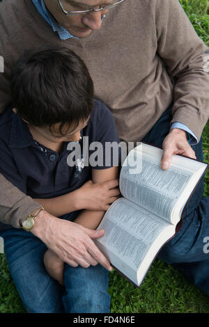 Father and son reading a bible. Foto Stock